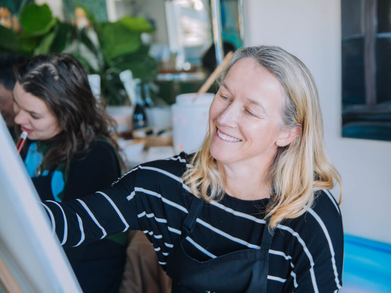 woman smiling at painting course